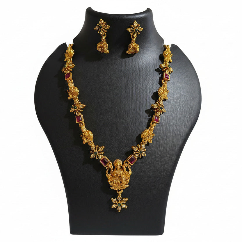Gold bracelet with red stones on a black mannequin hand against a blurred indoor background
